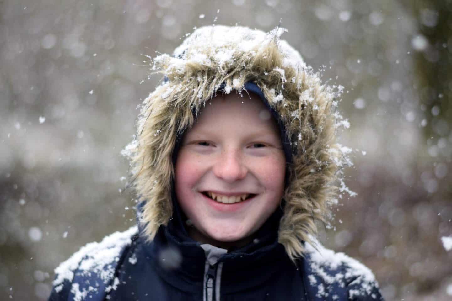 Boy with snow on the fur of his parka hood