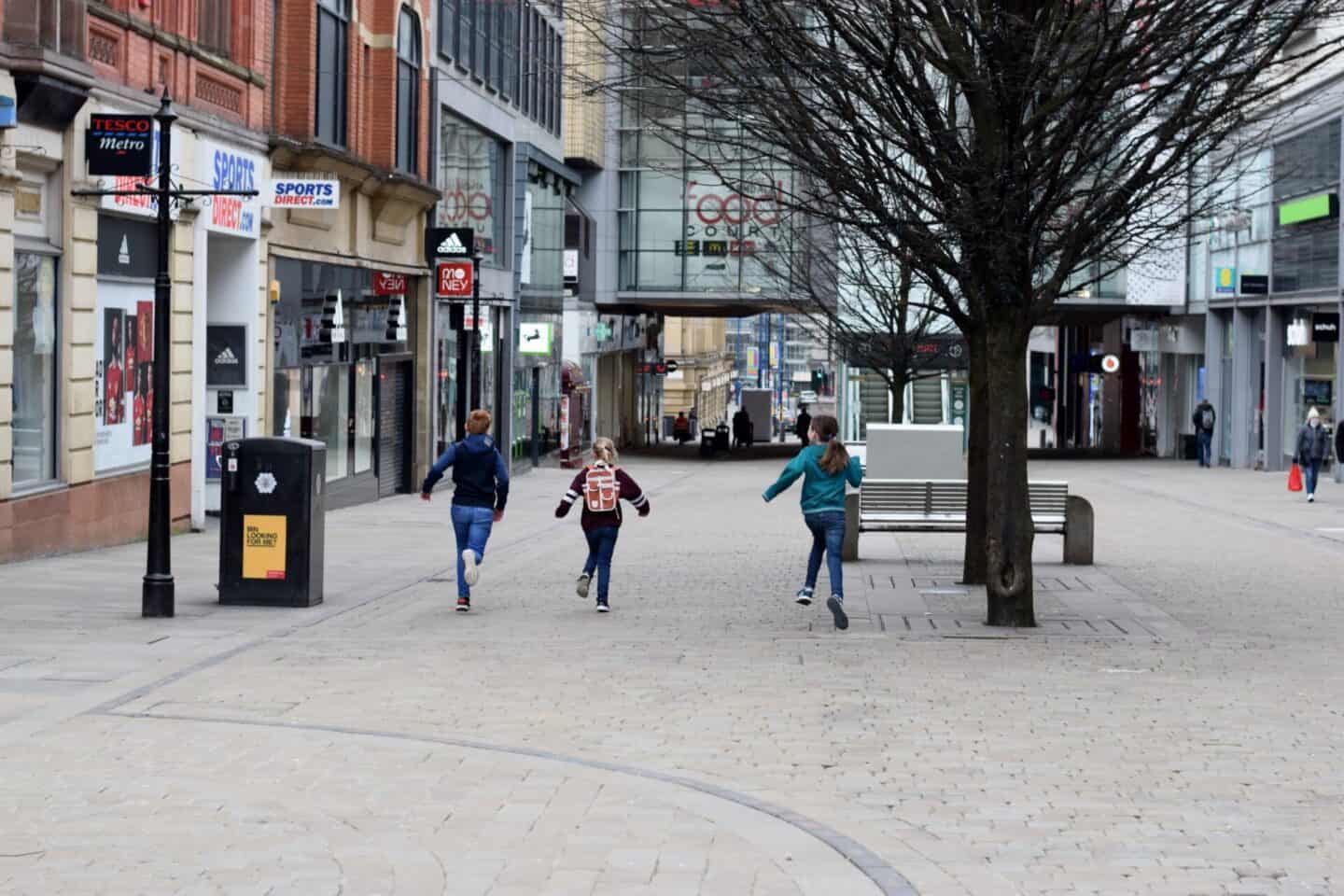 Children running through the centre of Manchester