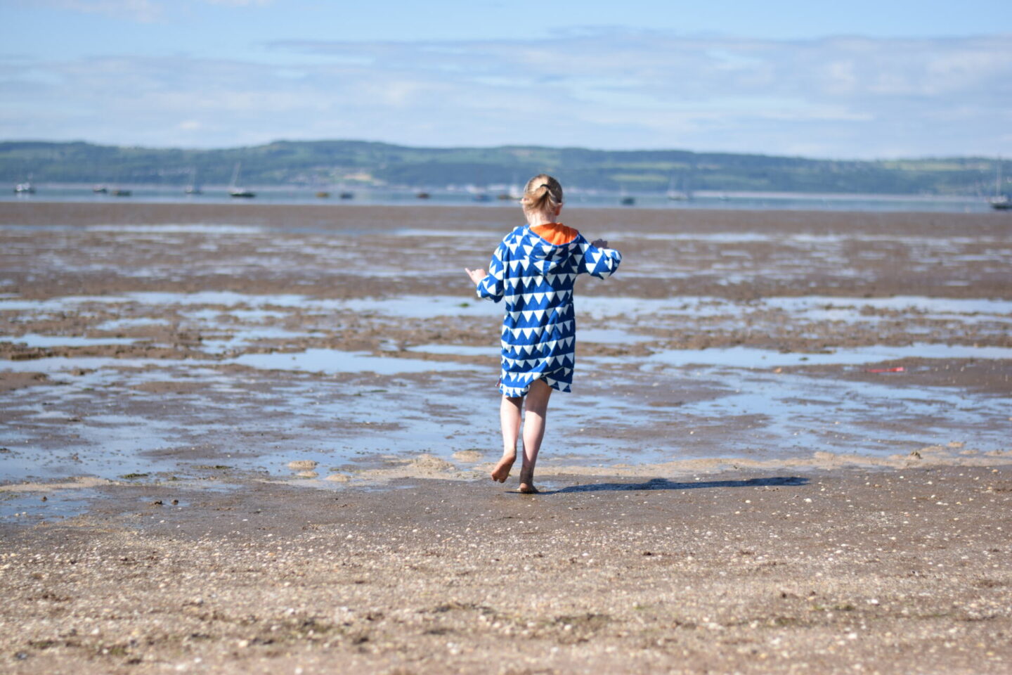 Little girl padding on the beach in West Kirby