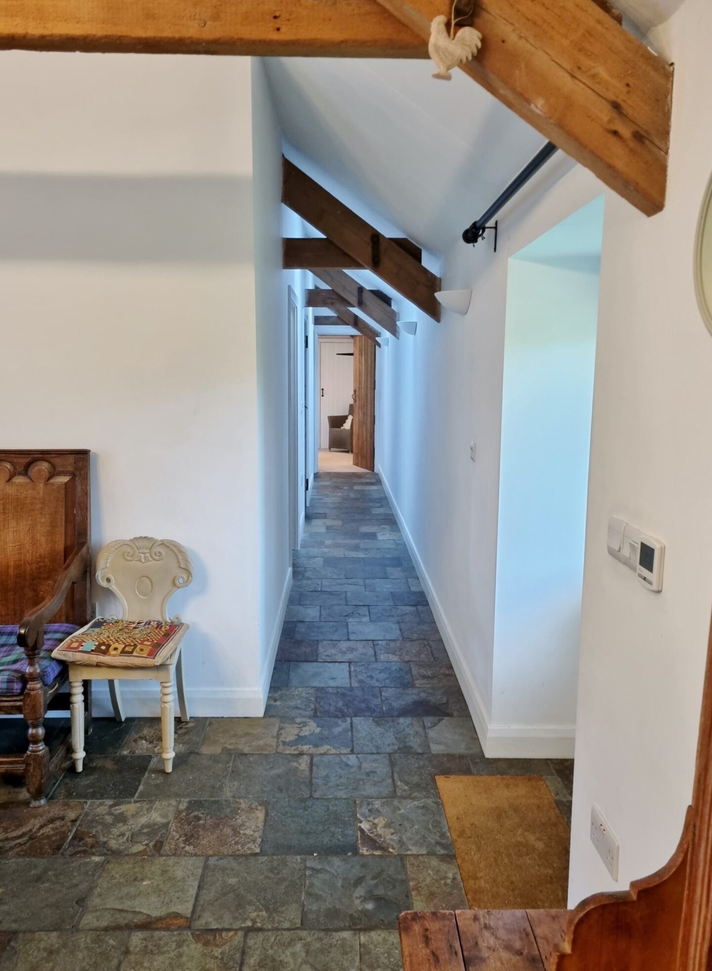 vaulted ceilings in the hall way with exposed beams