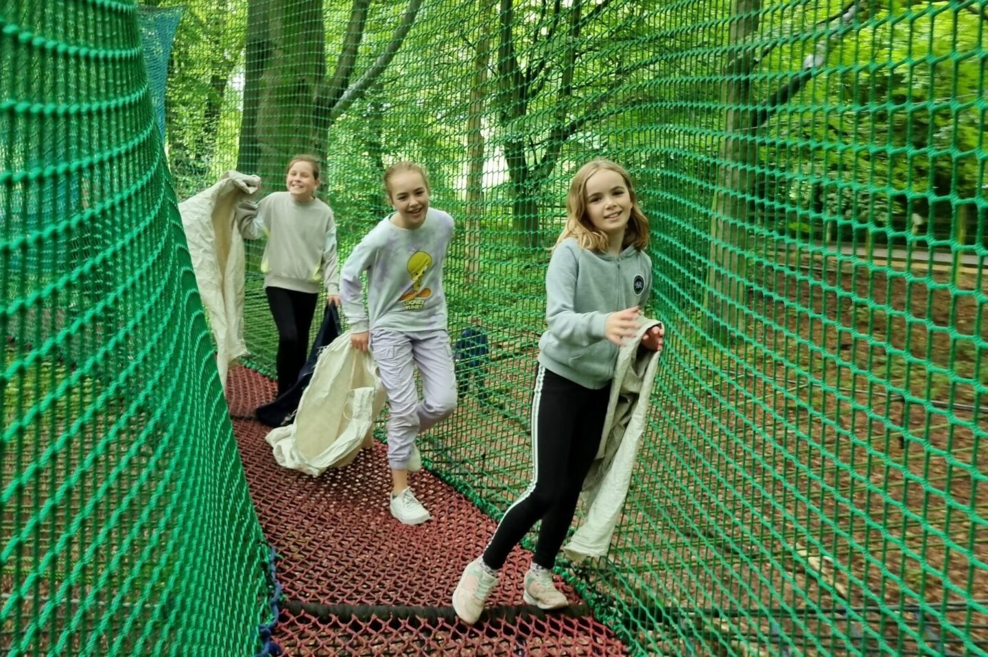 Girls carrying their sacks for the rope slides at Treetop Nets