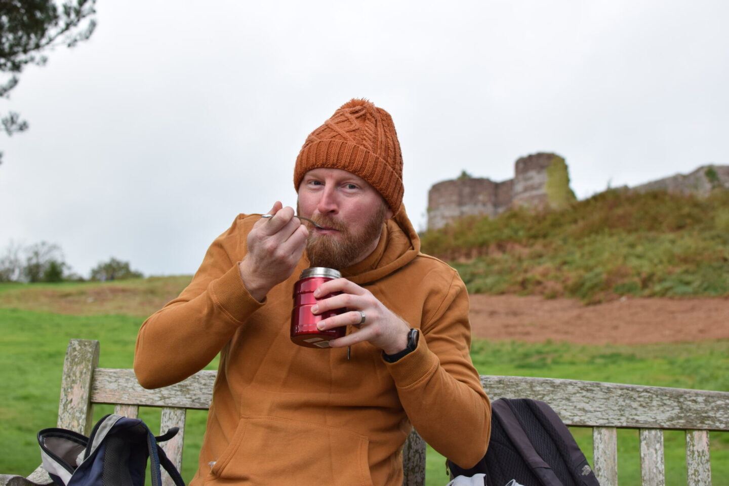 Dave eating hot chilli from his Thermos flask with Beeston Castle in the background