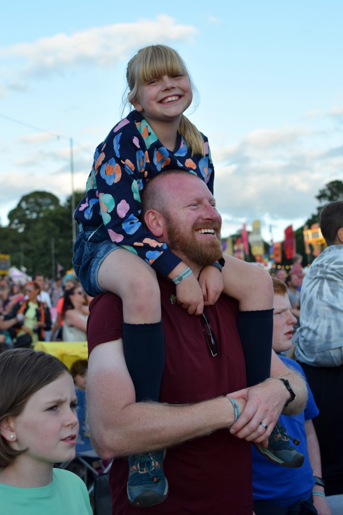 Amy sitting on Dave's shoulders and smiling at the camera
