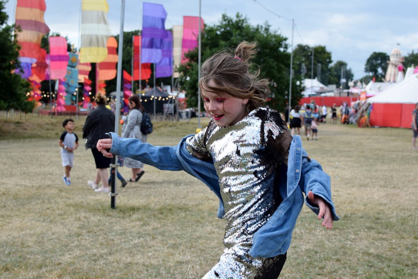 Chloe wearing a pre-loved sequin dress from Vinted with her brother's old denim shirt over the top
