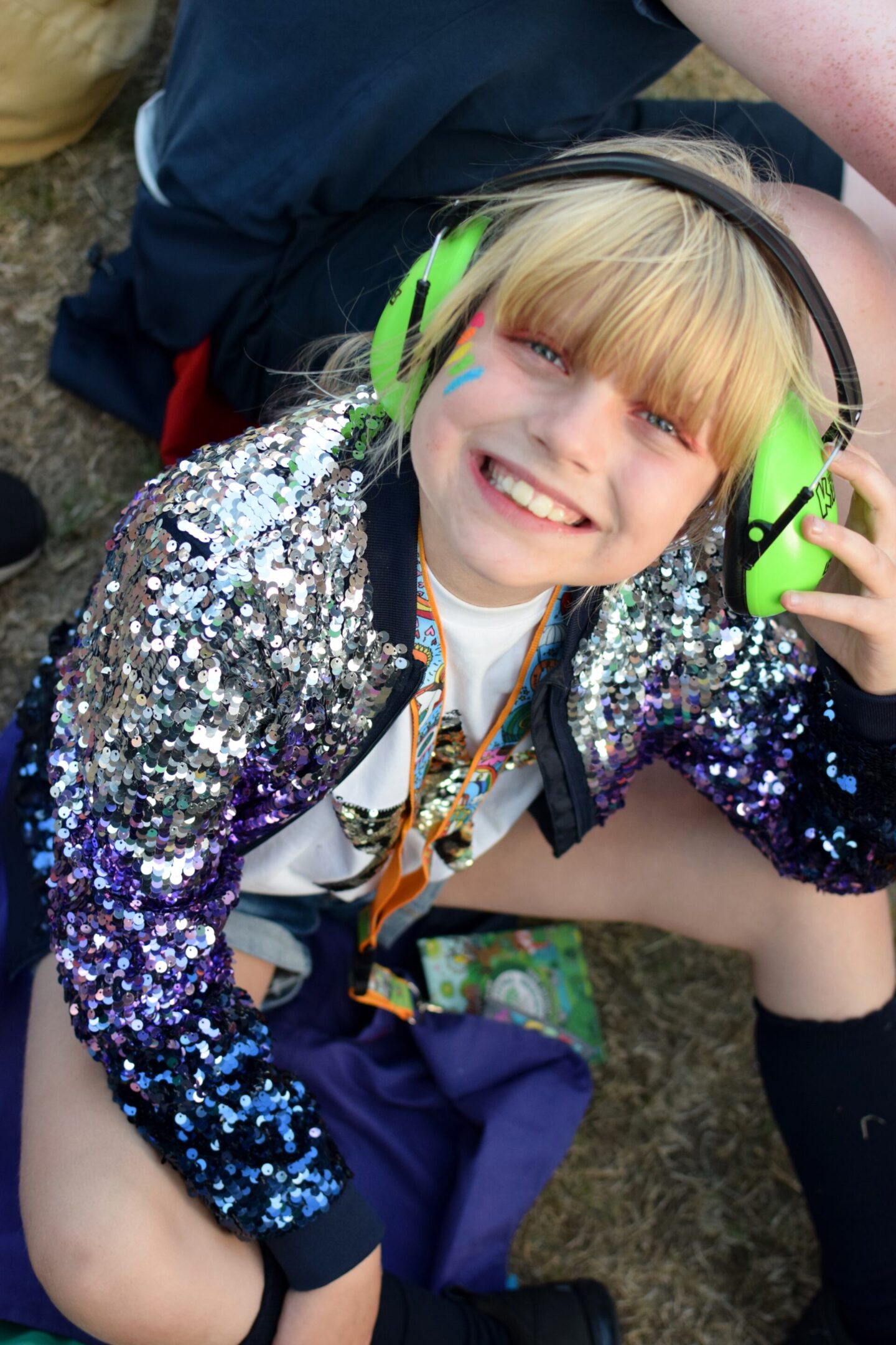 Amy at Camp Bestival Girl at festival wearing sequin jacket and ear defenders