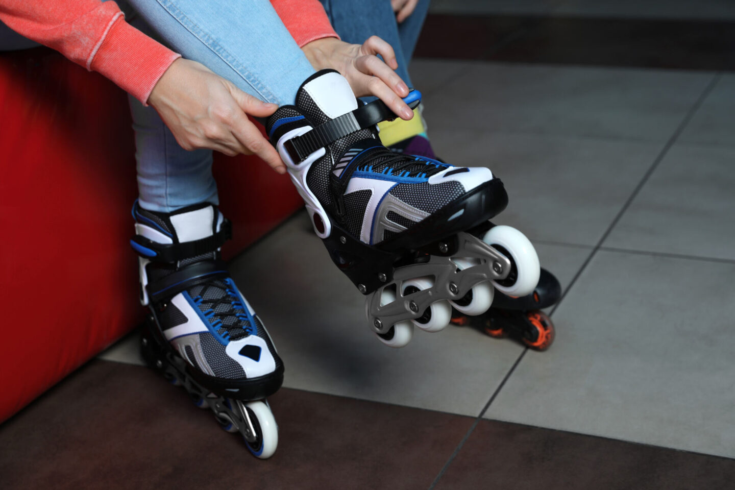 Woman putting on inline skates to go roller-skating indoors