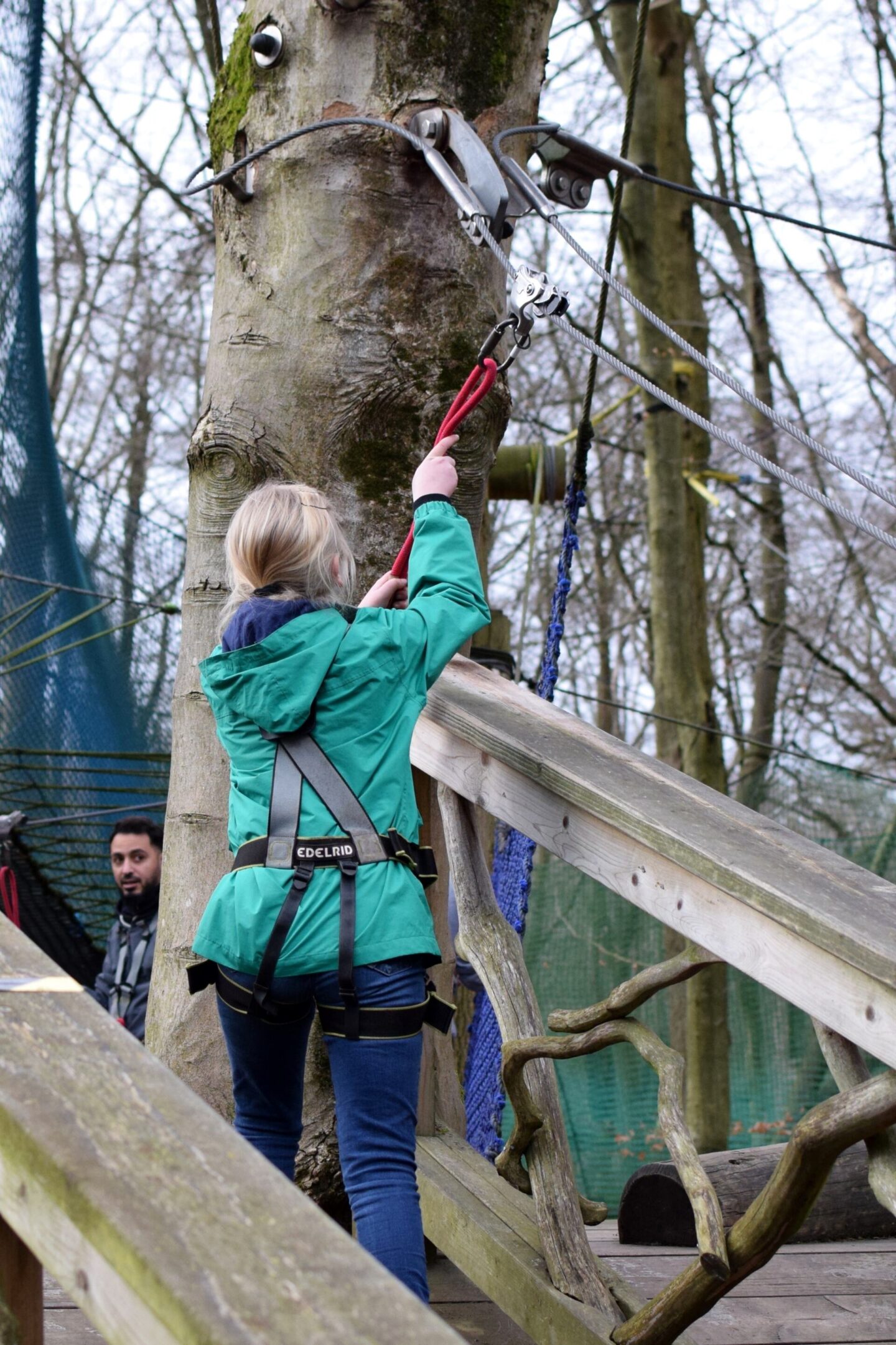 Amy can't quite reach to get her pulley over the end of the obstacle and needs some help from her brother