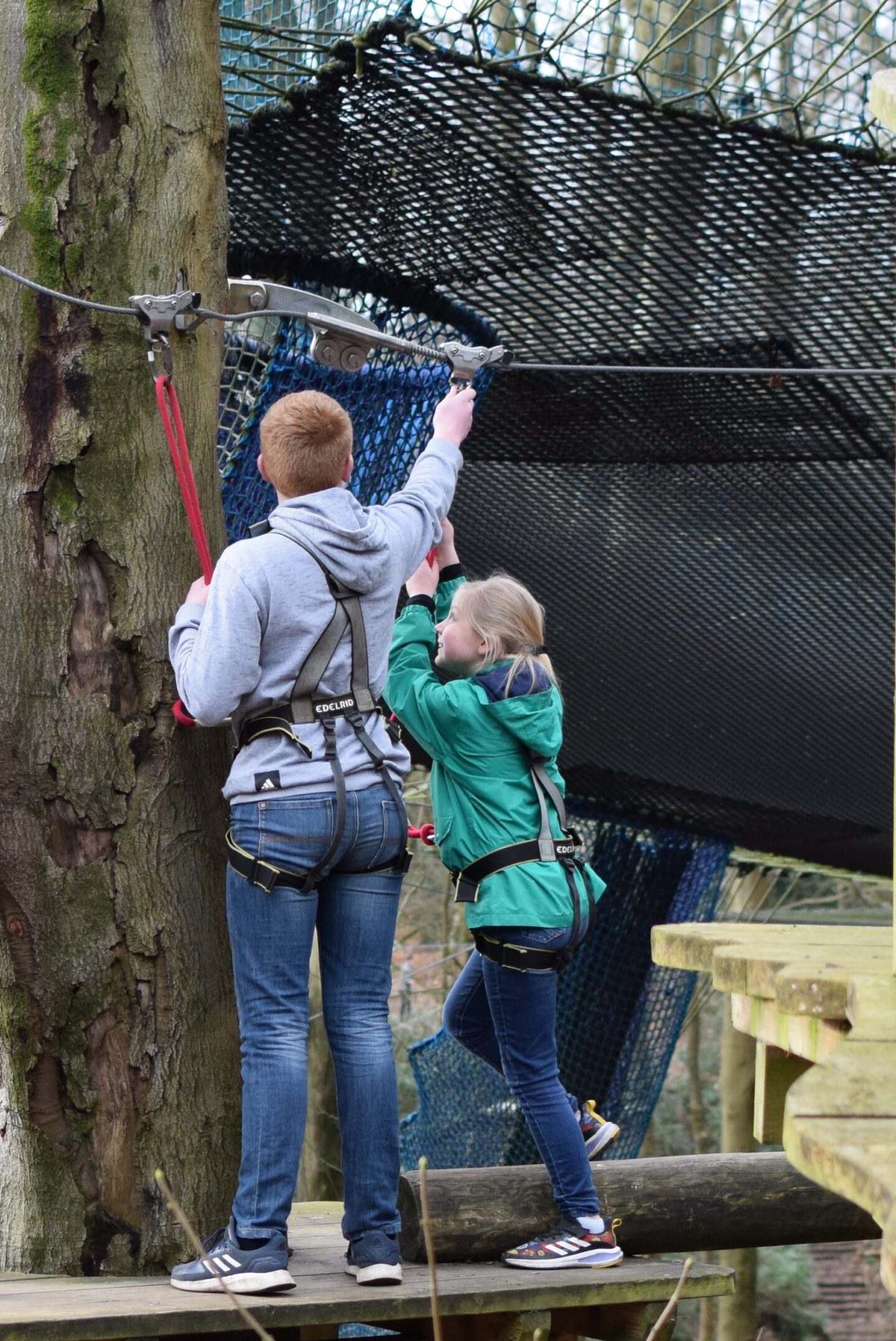Ben helps Amy to get her pulley into place at the end of an obstacle