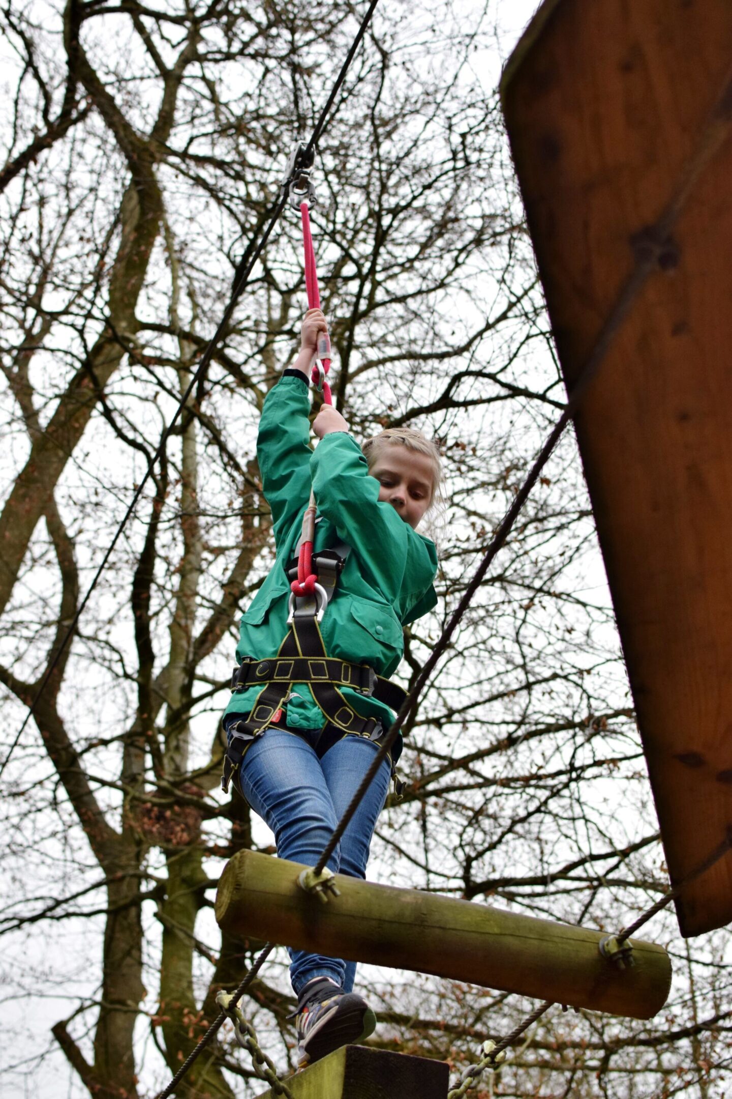 Amy holds her harness tightly whilst looking down at her feet to make sure she doesn't slip