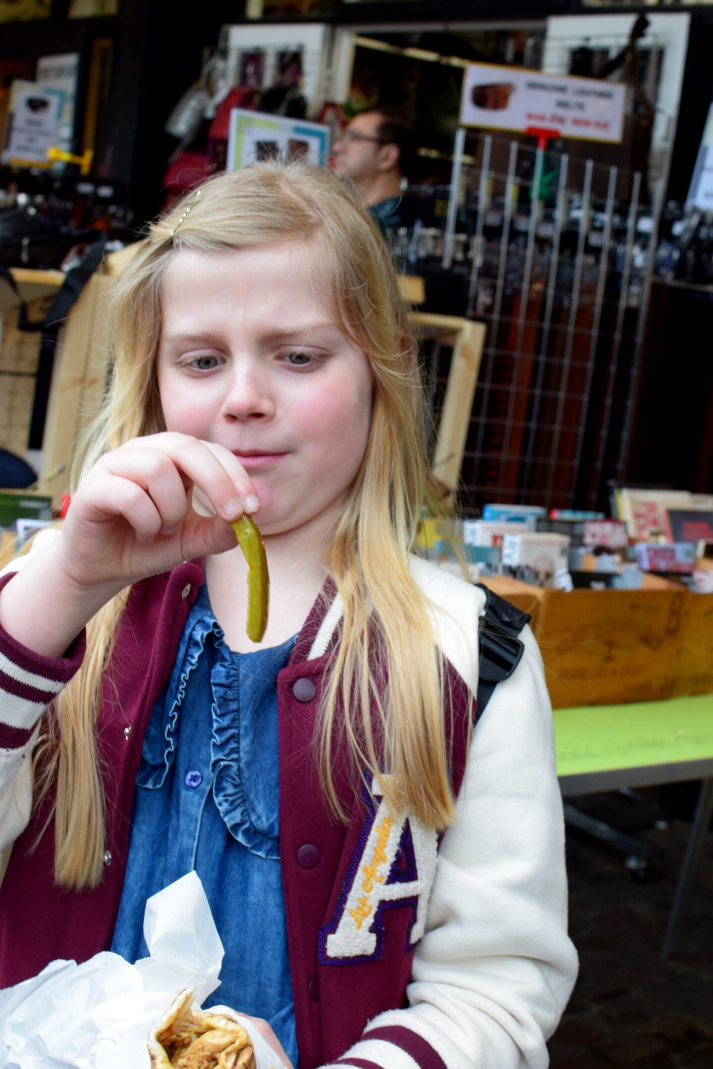 Amy looks suspiciously at the pickle she has just pulled out of her chicken shawarma from Lebanese by Mezzet at Camden Market