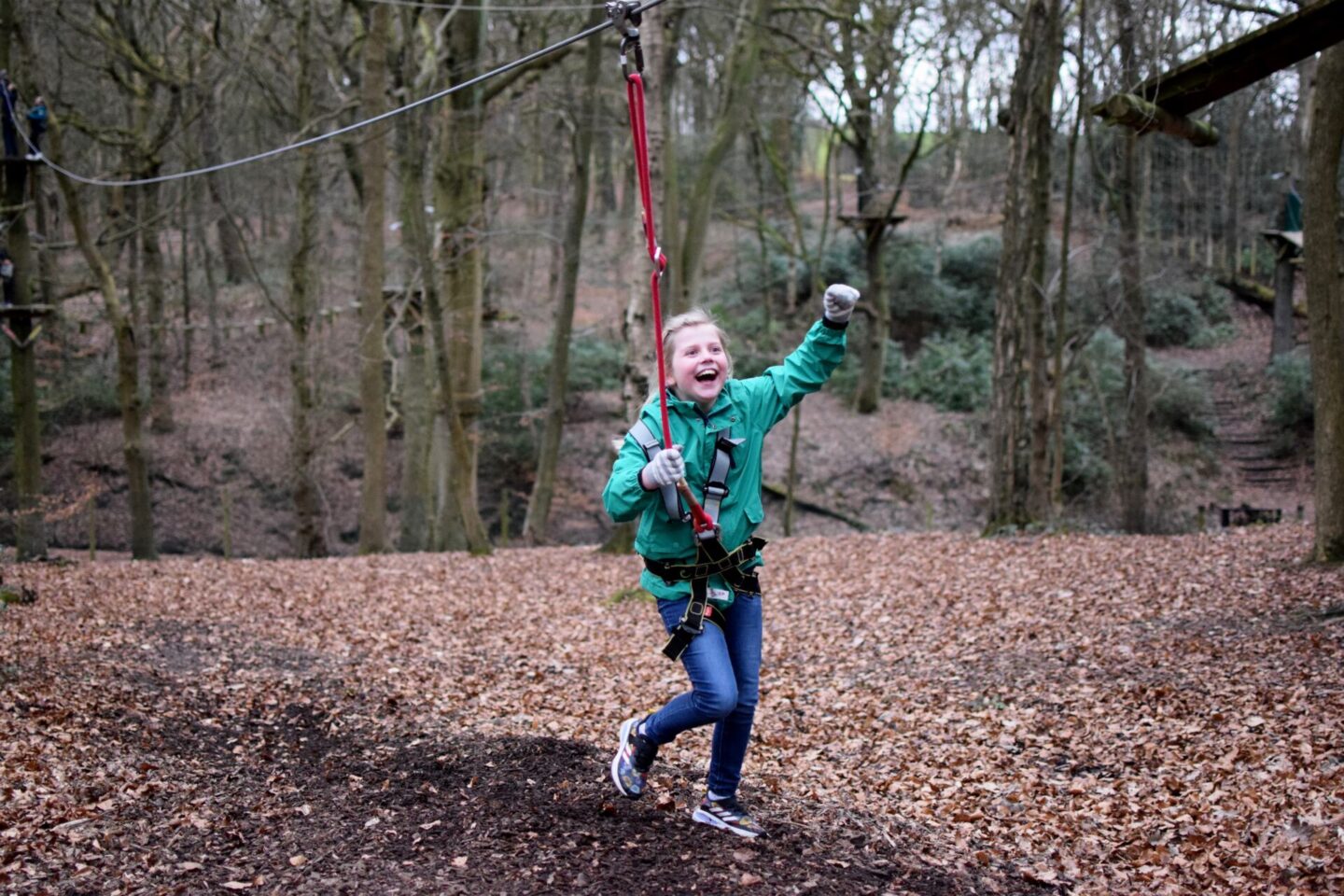 Amy lands on her feet after the last TreeTop Trek zipwire with a huge smile on her face and a celebratory fist in the air!