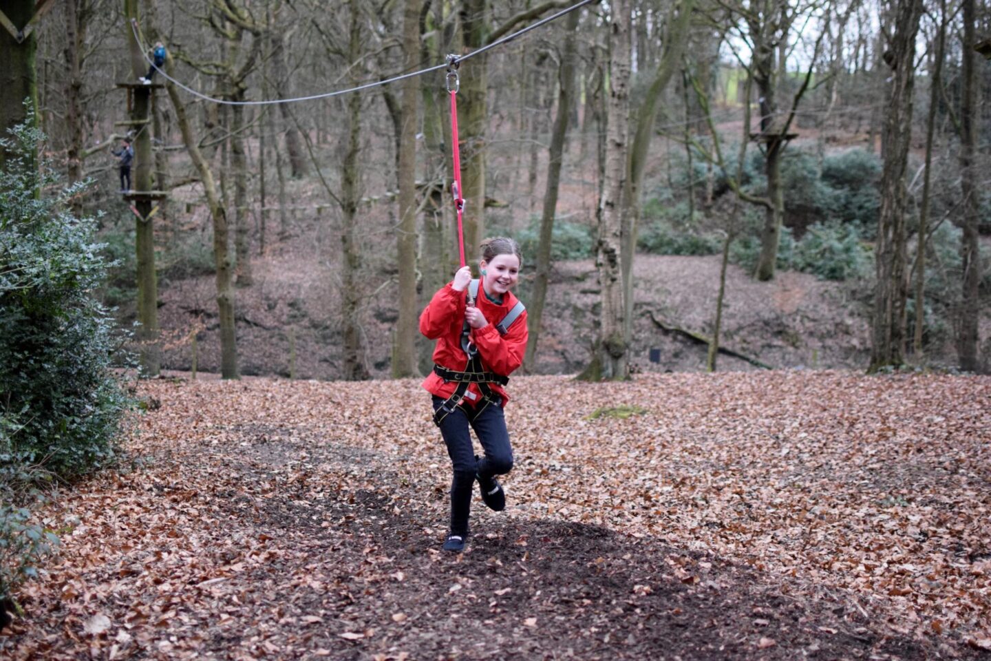 Chloe smiling broadly as she lands the final zipwire on her feet - not falling over or dragging herself across the mud this time!