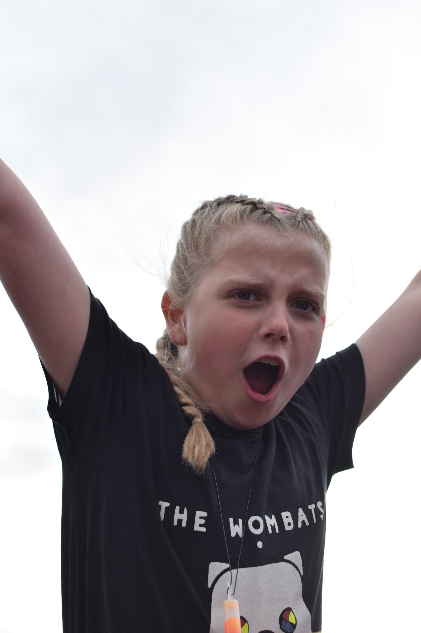 Amy singing along to The Wombats with her arms in the air