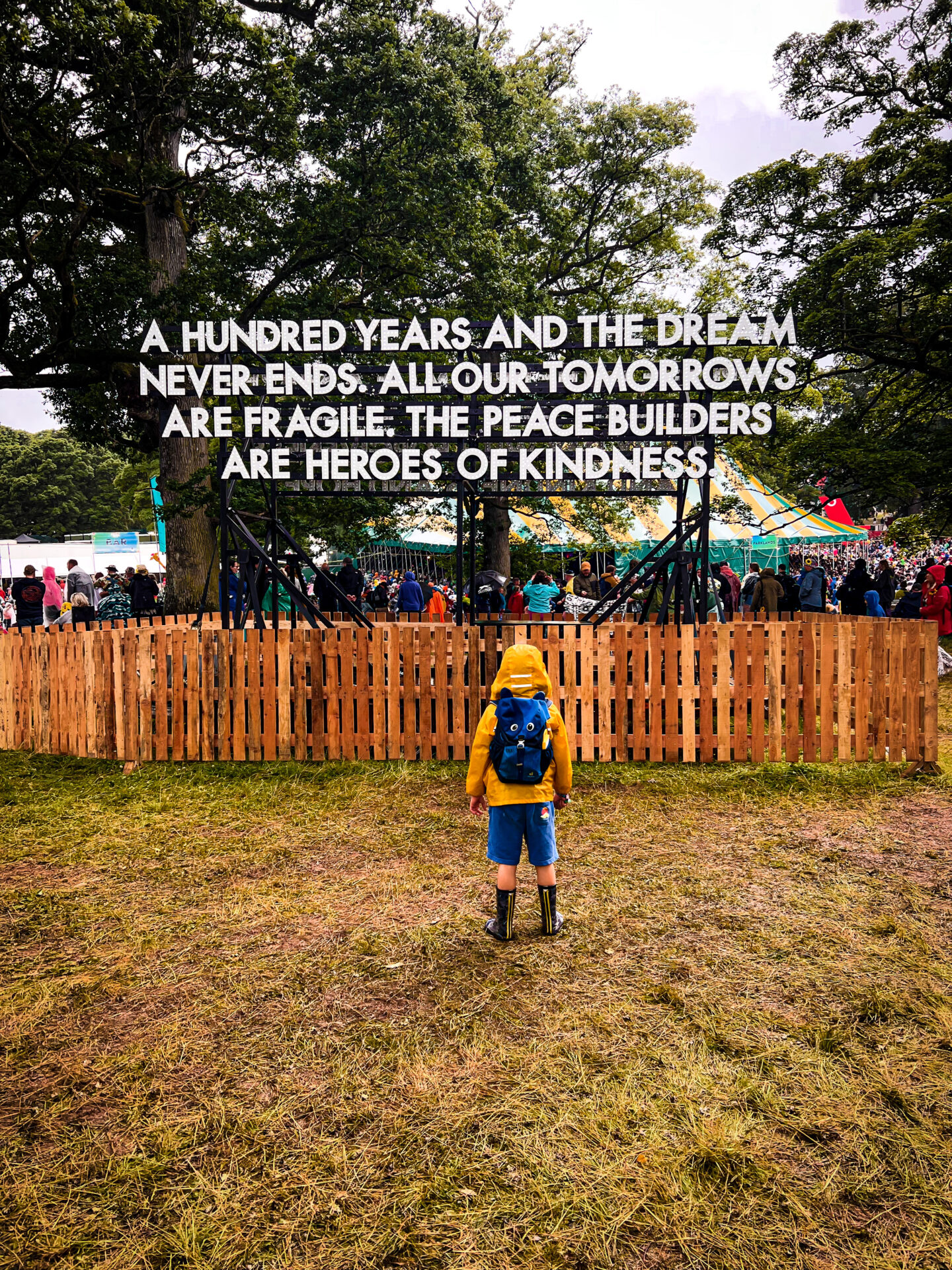 Kendal Calling with kids - child standing in front of sign