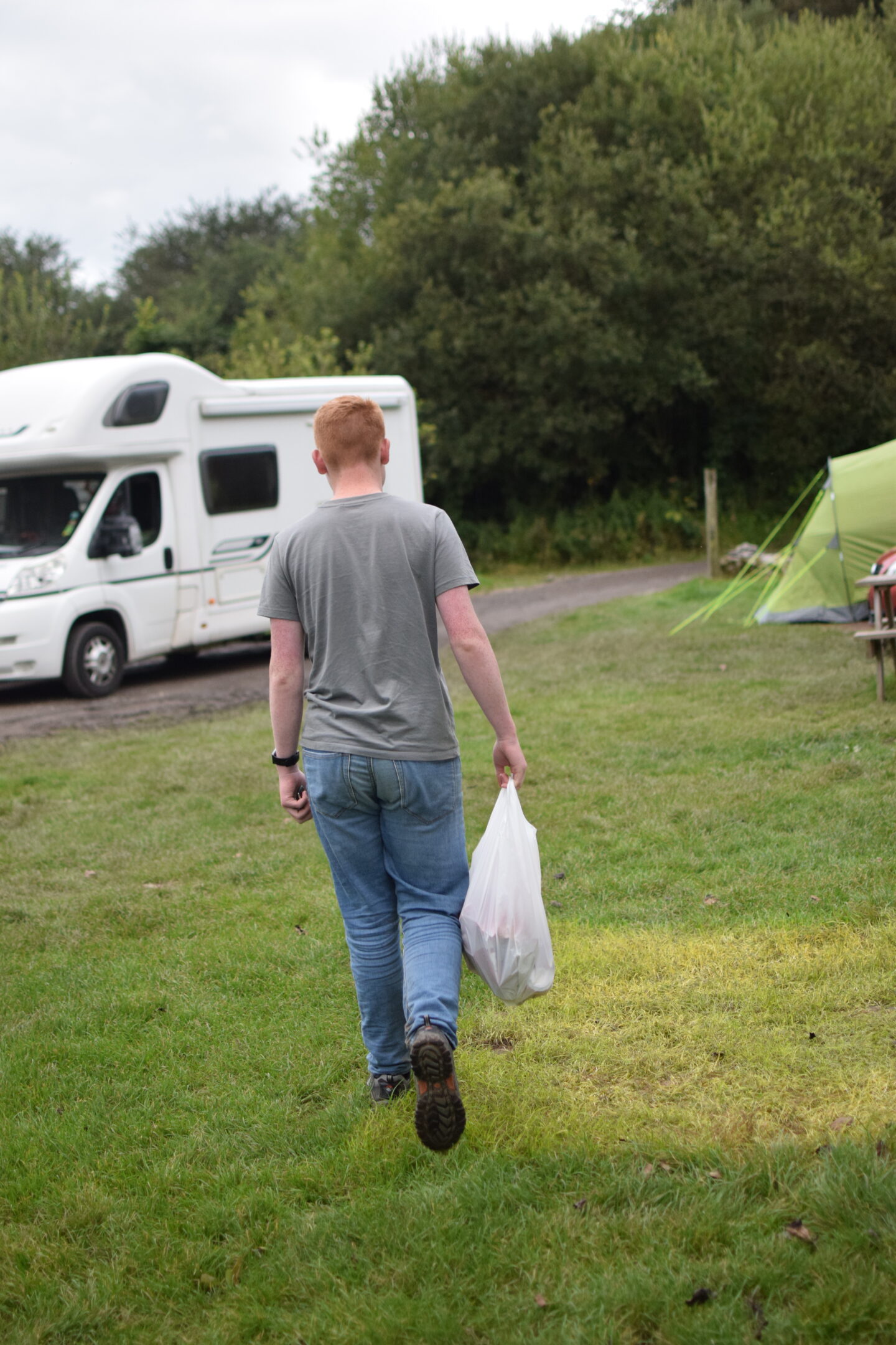 Ben carrying a bag of rubbish to the campsite bin