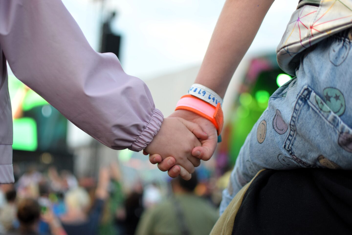 a close up of the girls holding hands on their Dad's shoulders