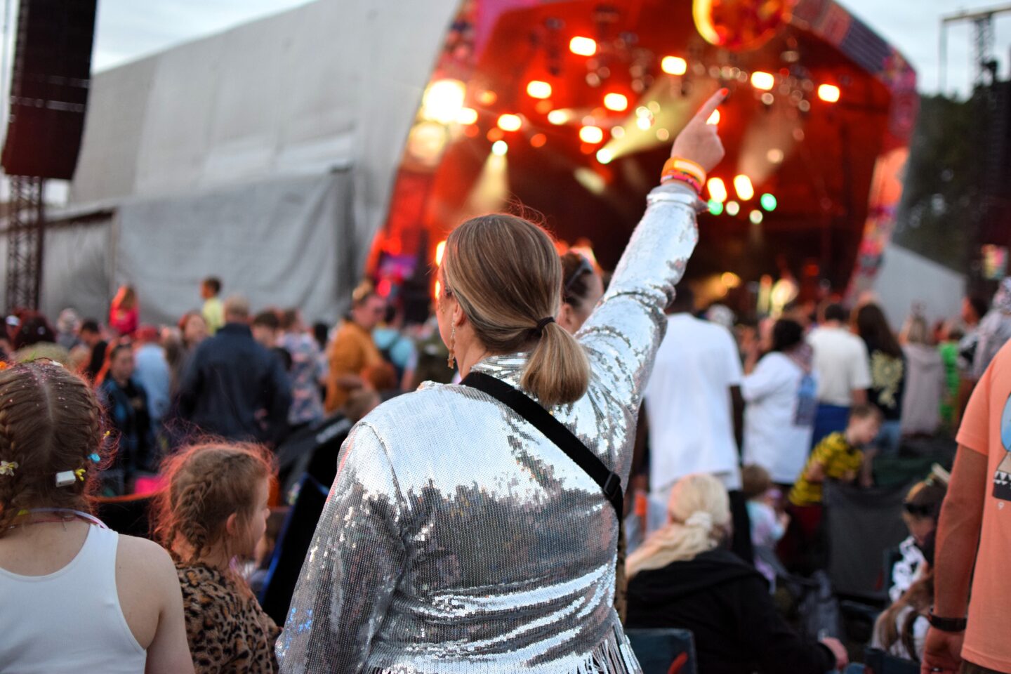 Lauren wearing a silver sequin jacket with one arm in the air enjoying Groove Armada
