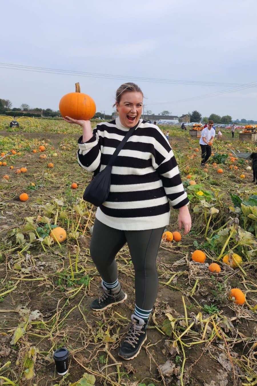 Pumpkin Picking at Burt's Barrow - Lauren standing in the pumpkin field showing off her chosen pumpkin