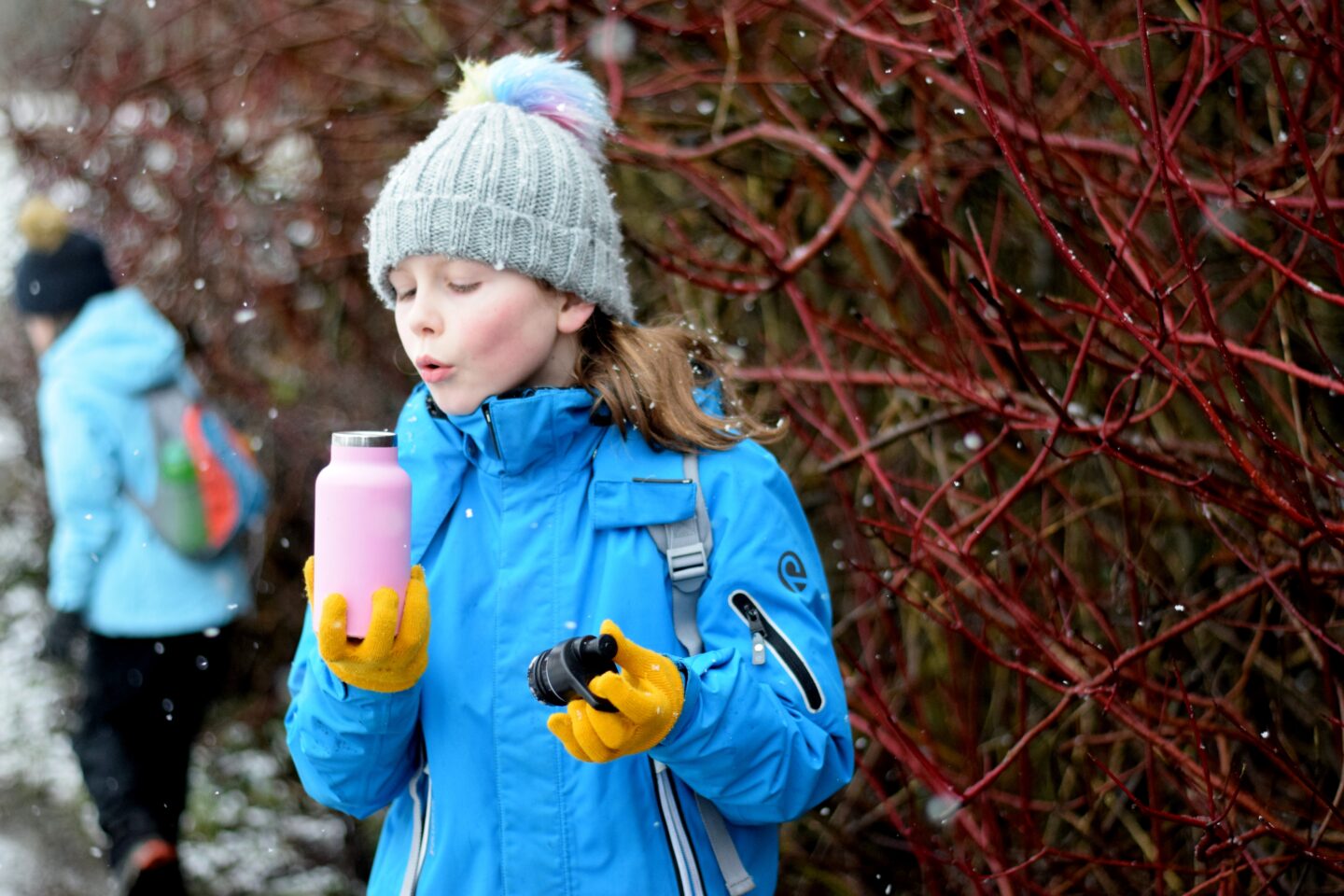 Chloe blowing her flask of hot drink on a winter walk