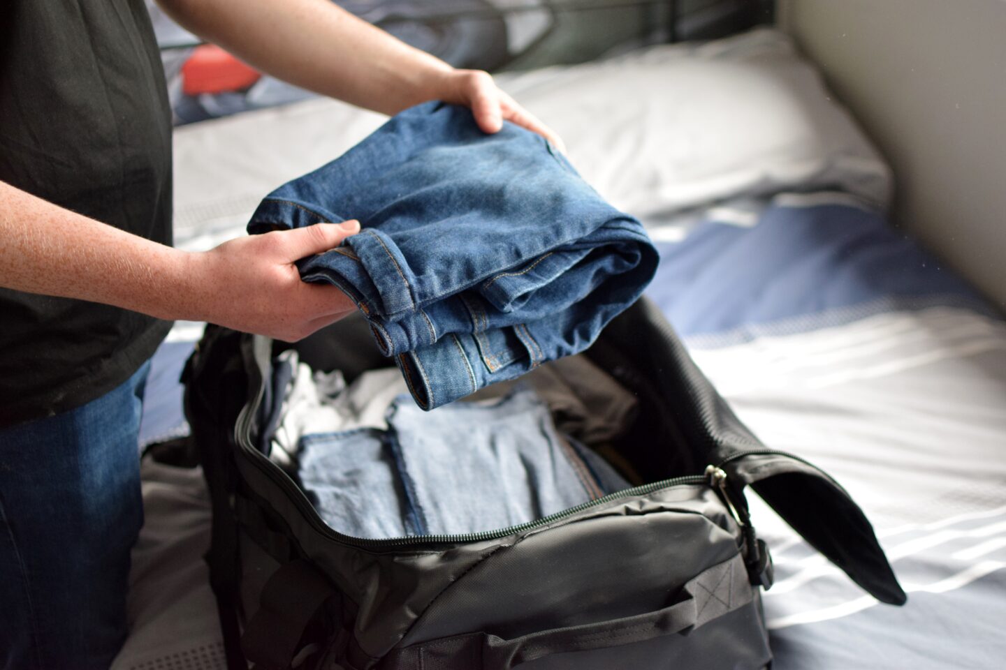 Ben packing his North Face duffle bag for camping trip
