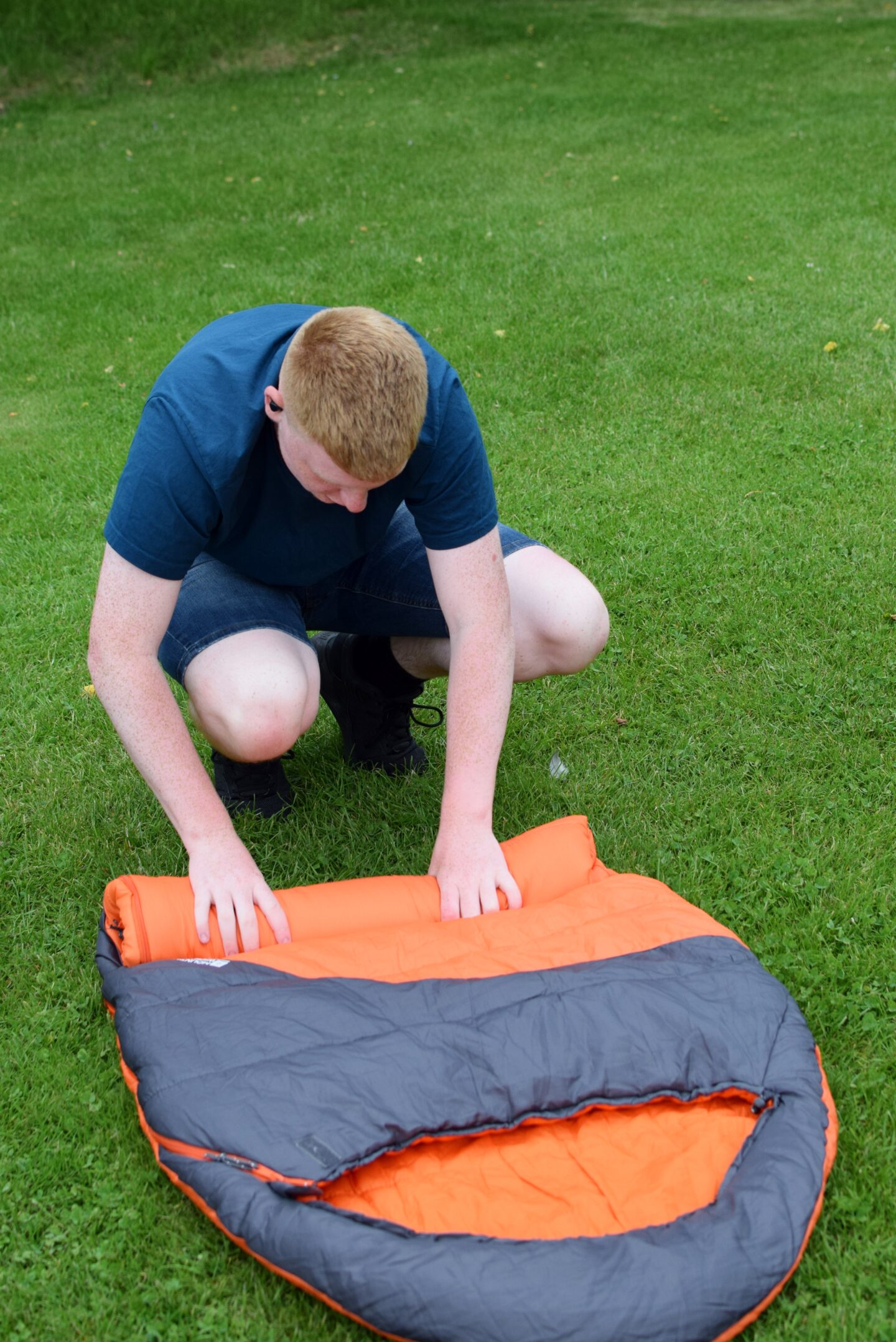 Ben rolling a sleeping bag for storage
