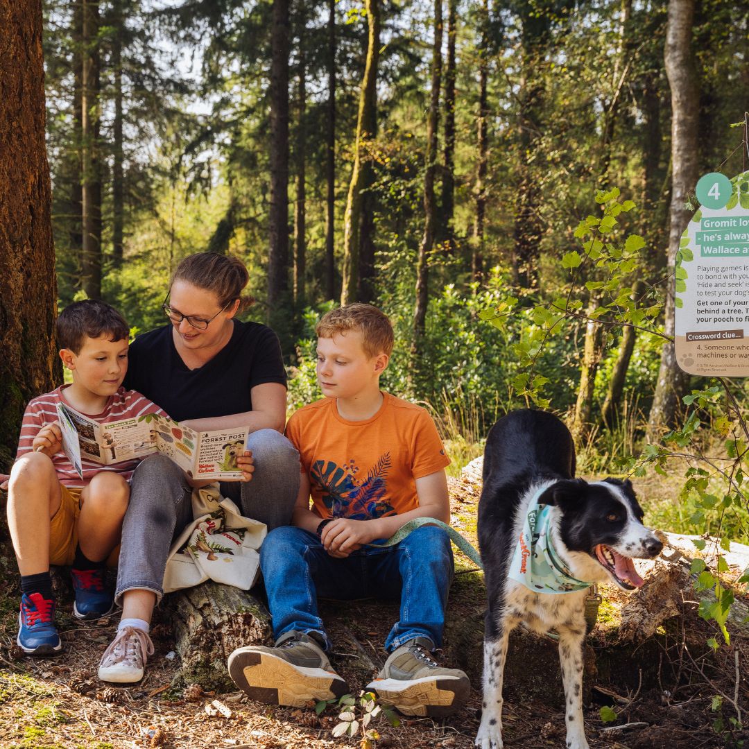 Family completing activity book at trail sign