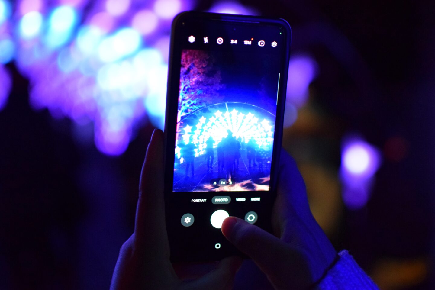 Mobile phone taking photo of star tunnel at Dunham Massey Christmas light trail