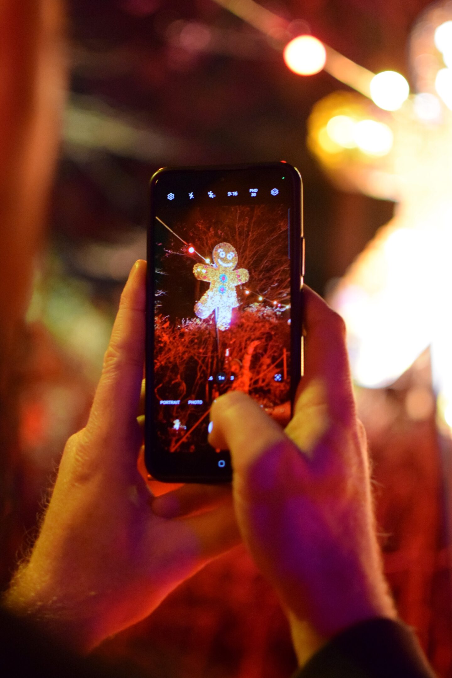 Close up of Dave taking a photo of Sequin gingerbread men on mobile phone