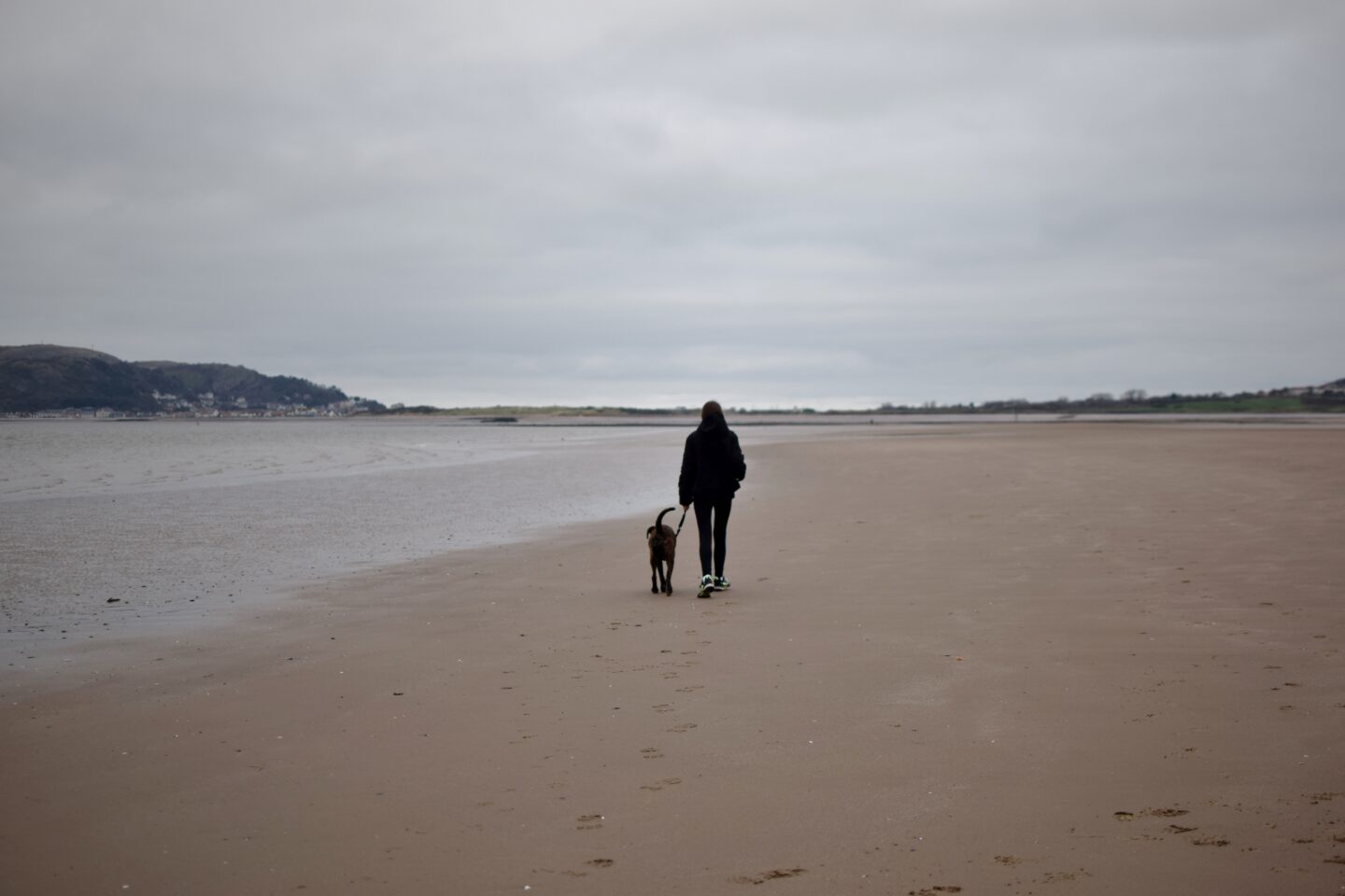 Chloe and Poppy walking on an empty Conwy Morfa Beach