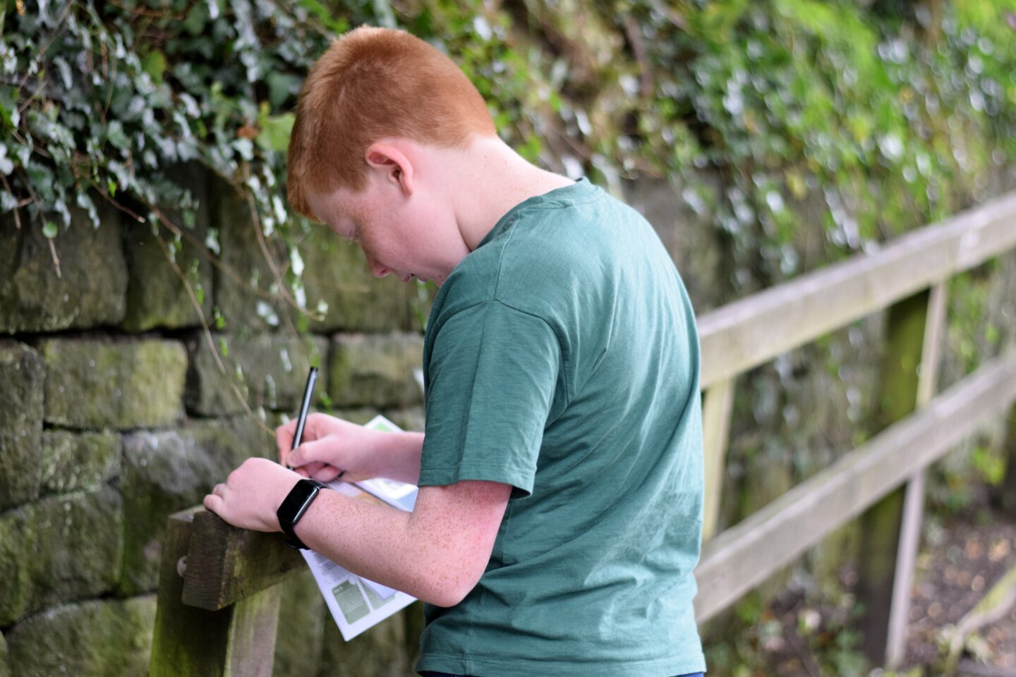 Ben filling in Treasure Trail booklet in Uppermill